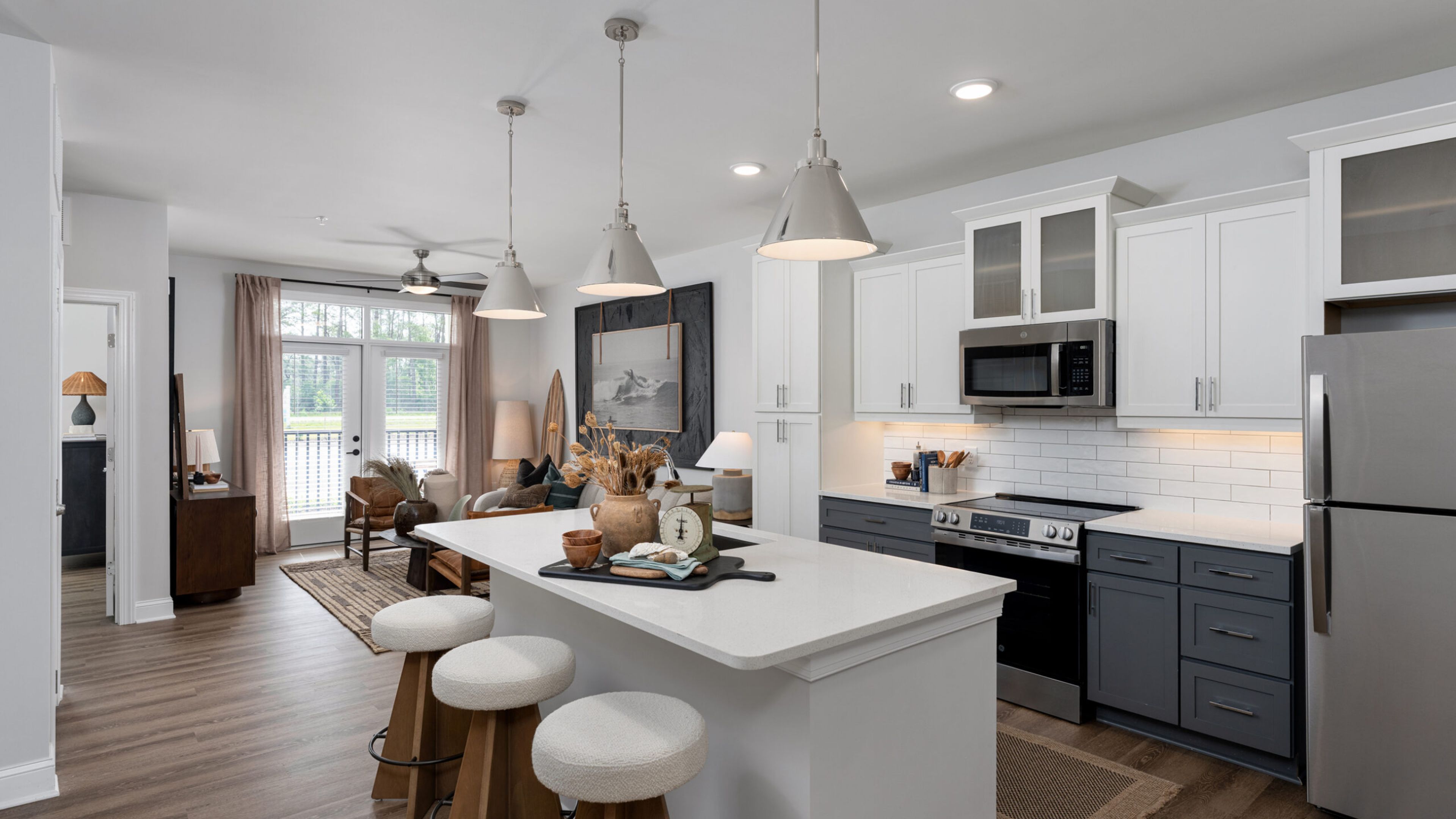Hawthorne Ocean Isle apartment living space and kitchen with small dining table, kitchen peninsula, and stainless steel appliances